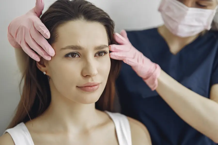 A professional injector administering dermal fillers to a client’s cheek, highlighting the longevity of Juvedérm® and RADIESSE® with a glowing, youthful look.